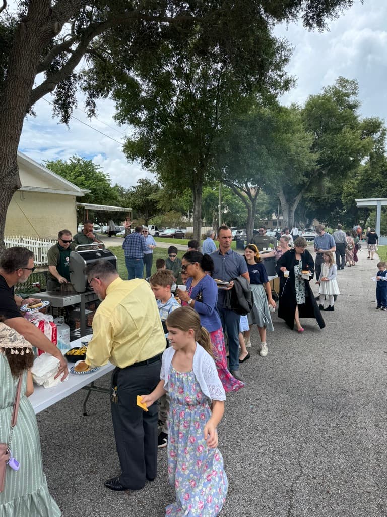 Long line of parishioners at an outdoor BBB gathering