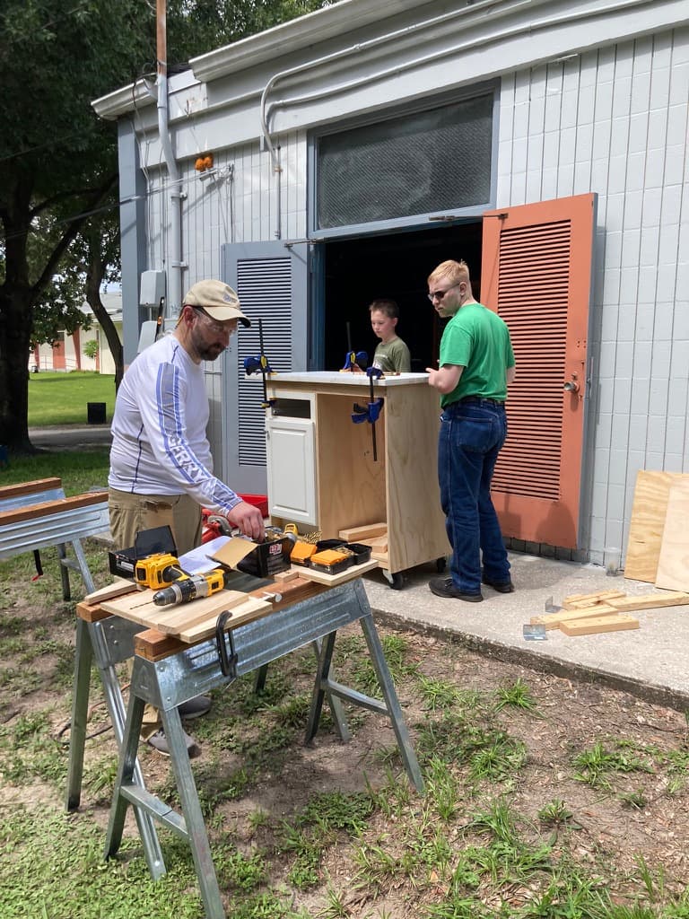Father and son working on a carpentry project at skill day